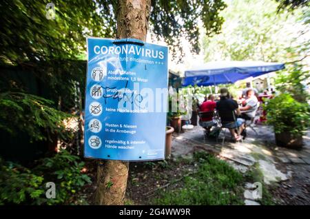 Munich, Bavière, Allemagne. 23 juin 2021. Une affiche d'avertissement du coronavirus vandalisé dans un parc de Munich avec un jardin d'enfants derrière lui. Un « fake » anti-vandale sur l'affiche. Credit: Sachelle Babbar/ZUMA Wire/Alay Live News Banque D'Images