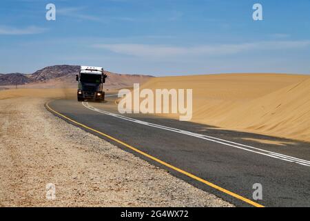 Camion sur la route goudronnée B4 près de Lüderitz, route au bord d'une dune dans le désert du Namib, région de Karas, Namibie Banque D'Images