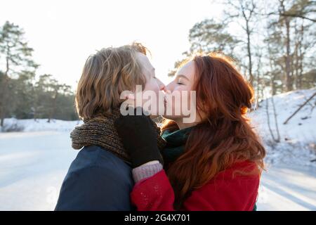 Un jeune couple romantique s'embrasse pendant le week-end d'hiver Banque D'Images