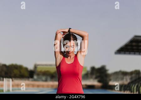 Une athlète féminine fait de l'exercice d'étirement dans le stade Banque D'Images