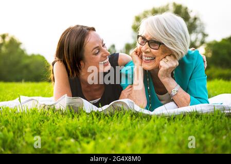 Bonne petite-fille et grand-mère couché sur le devant du parc Banque D'Images