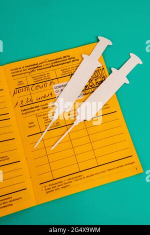 Certificat de vaccination et découpes de papier 2D de seringues blanches Banque D'Images