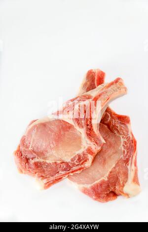 OS de côtelettes de porc cru dans un isoladet sur fond blanc. Banque D'Images