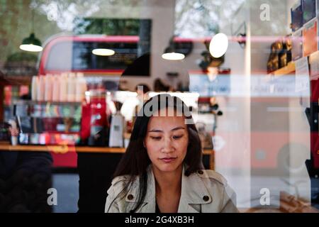 Femme adulte de taille moyenne assise au café Banque D'Images