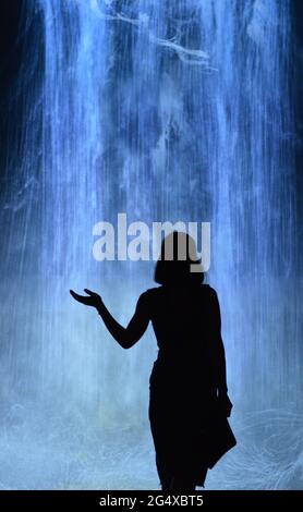 Ombre d'une femme sur fond de cascade artificielle bleue Banque D'Images