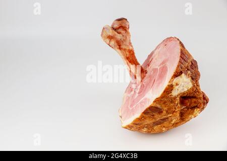 Jambon de porc glacé au miel avec gros os sur fond blanc. Banque D'Images