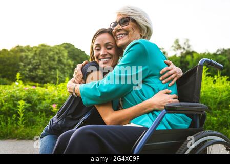 Bonne petite-fille et grand-mère se embrassant au parc Banque D'Images