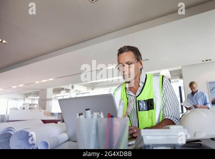 Architecte masculin concentré travaillant sur un ordinateur portable au bureau Banque D'Images