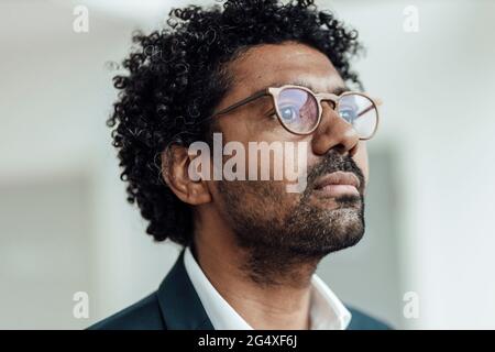 Homme d'affaires mûr portant des lunettes de vue en regardant loin Banque D'Images