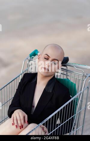 Femme bald transgenre dormant dans un panier Banque D'Images