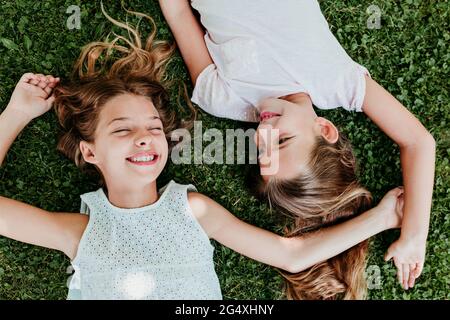 Joyeuses filles qui s'allonger sur l'herbe en été Banque D'Images