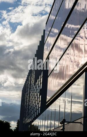 Espagne, Madrid, nuages reflétant dans la façade en verre du siège du Campus Repsol Banque D'Images