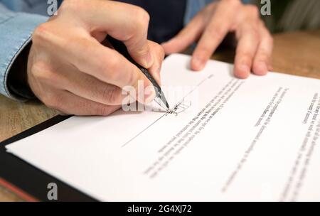 Homme professionnel faisant la signature sur le document dans le bureau Banque D'Images