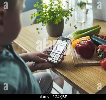 Garçon avec un père pointant sur une image végétale sur un smartphone Banque D'Images