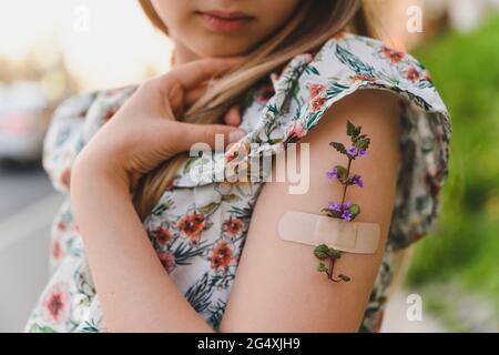 Bras de fille avec fleur et aide-bande Banque D'Images