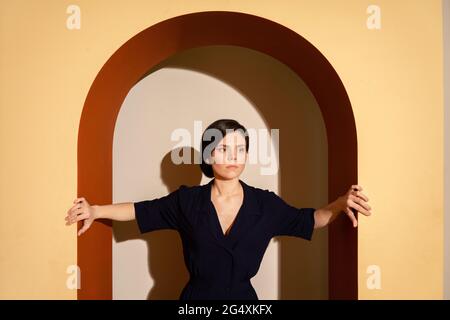 Jeune femme debout sous l'arche Banque D'Images