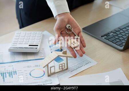 Concept hypothécaire. Femme main tenant la clé avec porte-clés en forme de maison. Immobilier, déménagement ou location de biens Banque D'Images