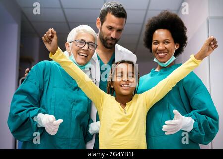 Équipe de médecins expérimentés hautement qualifiés avec enfant patient après un traitement réussi Banque D'Images