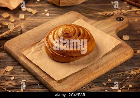 Petits pains à la cannelle frais faits maison sur fond de bois Banque D'Images