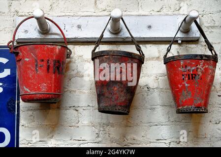 Trois seaux de feu rouge dans un atelier à Beamish Village, comté de Durham, Angleterre, Royaume-Uni, 12 juin 2021 Banque D'Images