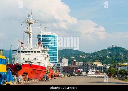Cargo amarré dans le port de la ville avec la toile de fond des montagnes Banque D'Images