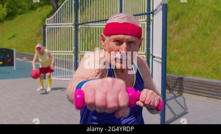 Senior homme grand-père faire sport entraînement boxe fitness aérobic cardio exercice avec haltères Banque D'Images