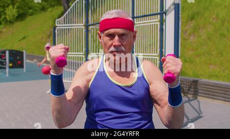 Senior homme grand-père faire sport entraînement boxe fitness aérobic cardio exercice avec haltères Banque D'Images