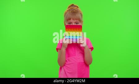 Petite fille d'enfants presser appuie coloré anti-stress écran tactile pousser pop il populaire jouet Banque D'Images