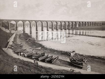 Vue de la fin du XIXe siècle sur le pont frontalier royal enjambant la rivière Tweed entre Berwick-upon-Tweedmouth et Northumberland, en Angleterre. Le viaduc de chemin de fer de 659 mètres (2,162 pi) de long avec 28 arches a été construit entre 1847 et 1850 et ouvert par la reine Victoria. L'ingénieur qui l'a conçu était Robert Stephenson (fils du pionnier des chemins de fer George Stephenson). Banque D'Images