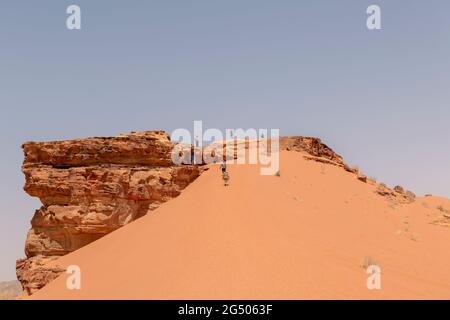 Touristes explorant la zone protégée de Wadi Rum. Wadi Rum ou Vallée de la Lune est célèbre pour son paysage désertique, ses vallées désertiques et ses dunes. Banque D'Images