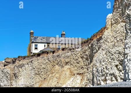 Vieux chalets perchés sur le bord de la falaise à Birling Gap en raison de l'érosion côtière sévère, près d'Eastbourne East Sussex Angleterre Banque D'Images