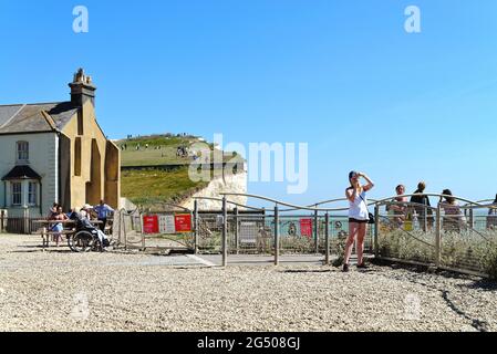 Le sommet instable de la falaise de craie à Birling Gap avec des touristes qui profitent d'une chaude journée d'été, Eastbourne East Sussex Angleterre Royaume-Uni Banque D'Images