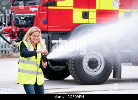 Kim Leadbeater, le candidat travailliste à l'élection partielle Batley et Spren, utilise un tuyau d'incendie lors d'une visite à Angloco, qui fabrique des moteurs d'incendie et des véhicules de secours utilisés dans tout le pays et dans le monde, alors qu'il est sur la piste de campagne avant l'élection partielle du 1er juillet. Date de la photo: Jeudi 24 juin 2021. Banque D'Images