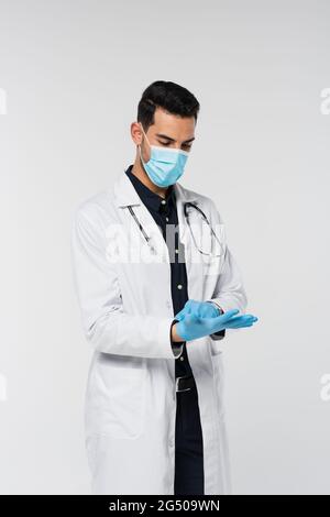 Médecin musulman dans un masque médical portant des gants en latex isolés sur du gris Banque D'Images