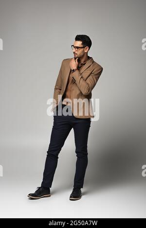 Homme d'affaires arabe barbu qui regarde sur fond gris Banque D'Images