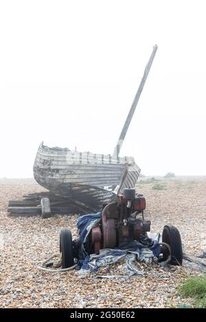 Vieux bateau de pêche en décomposition, vue du côté de la mer, en regardant vers les propriétés sur Coast Drive, Dungeness, Romney Marsh, Kent, Angleterre, ROYAUME-UNI Banque D'Images