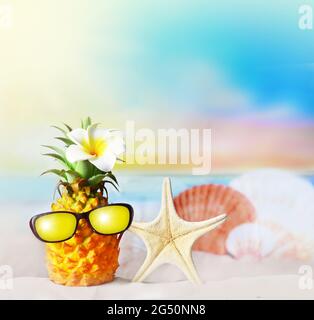 Ananas avec fleur et seashell sur la plage. Concept d'été. Banque D'Images