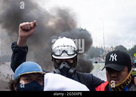 Bogota, Colombie. 23 juin 2021. Un démonstrateur de la ligne de front 'Primera Linea' lève son poing alors que les manifestations se déroulent dans le nord de Bogota, en Colombie, le 22 juin, après qu'un manifestant soit décédé dans un cas d'abus de pouvoir de la police lors d'affrontements avec la police anti-émeute de Colombie (ESMAD) le 22 juin 2021. Crédit : long Visual Press/Alamy Live News Banque D'Images