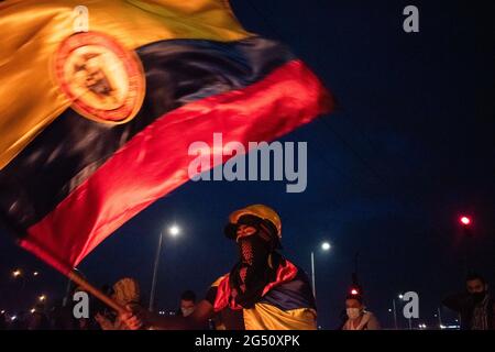 Bogota, Colombie. 23 juin 2021. Un manifestant fait monter un drapeau colombien alors que les manifestations se sont manifestés dans le nord de Bogota, en Colombie, le 22 juin, après qu'un manifestant ait été décédé dans un cas d'abus d'autorité de la police lors d'affrontements avec la police anti-émeute de Colombie (ESMAD) le 22 juin 2021. Crédit : long Visual Press/Alamy Live News Banque D'Images