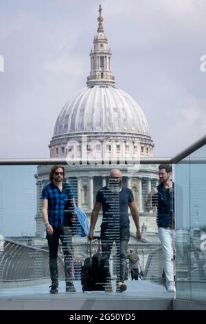 Avec le dôme de la cathédrale St Paul au loin, les piétons traversent la Tamise sur le pont du Millénaire, le 24 juin 2021, à Londres, en Angleterre. La plus récente traversée de la rivière de Londres depuis plus de 100 ans a coïncidé avec le Millenium. Elle a été achevée à la hâte et ouverte au public le 10 juin 2000, quand environ 100,000 personnes l'ont traversée pour découvrir que la structure oscille tellement qu'elle a été forcée de fermer 2 jours plus tard. Au cours des 18 prochains mois, les concepteurs ont ajouté des amortisseurs pour arrêter sa vacillement, mais il symbolisait déjà ce qui était embarrassant et qui ne parvenait pas à la fierté britannique. Maintenant le Stan britannique Banque D'Images