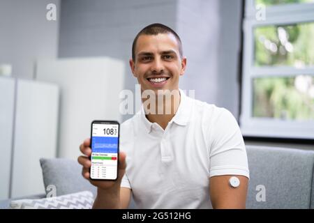 Homme utilisant le capteur de diabète de la surveillance à distance continue de glucose Banque D'Images