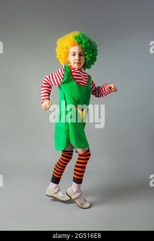 La petite fille saute dans un uniforme de clown Banque D'Images