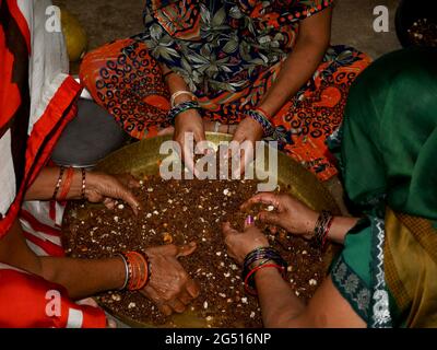 Trois femmes traditionnelles faisant de Jaggery sec fruit doux pour le festival en inde. Banque D'Images