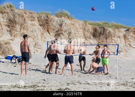 Des garçons jouant au Beach-volley lors d'une journée ensoleillée d'été à West Wittering, près de Chichester, West Sussex, Angleterre Banque D'Images