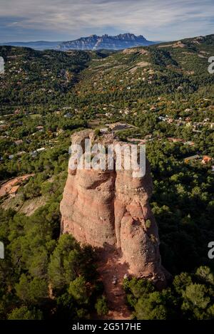 Un grimpeur descendant le rocher de Cavall Bernat à Matadepera, à Sant Llorenç del Munt i l'Obac. En arrière-plan, la montagne de Montserrat (Barcelone) Banque D'Images