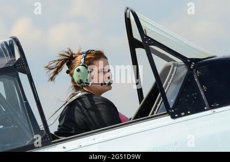 Une femme pilote se promenant dans un avion avec le capot du poste de pilotage ouvert. Leah Hammond aux commandes d'un avion de Harvard T-6 de la Seconde Guerre mondiale Banque D'Images