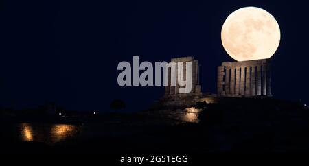 Cap Sounion, Grèce. 24 juin 2021. La pleine lune s'élève au-dessus du Temple de Poséidon au cap Sounion, à environ 70 km au sud-est d'Athènes, Grèce, le 24 juin 2021. Crédit: Marios Lolos/Xinhua/Alamy Live News Banque D'Images