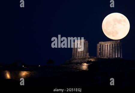 Cap Sounion, Grèce. 24 juin 2021. La pleine lune s'élève au-dessus du Temple de Poséidon au cap Sounion, à environ 70 km au sud-est d'Athènes, Grèce, le 24 juin 2021. Crédit: Marios Lolos/Xinhua/Alamy Live News Banque D'Images