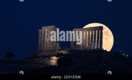 Cap Sounion, Grèce. 24 juin 2021. La pleine lune s'élève au-dessus du Temple de Poséidon au cap Sounion, à environ 70 km au sud-est d'Athènes, Grèce, le 24 juin 2021. Crédit: Marios Lolos/Xinhua/Alamy Live News Banque D'Images