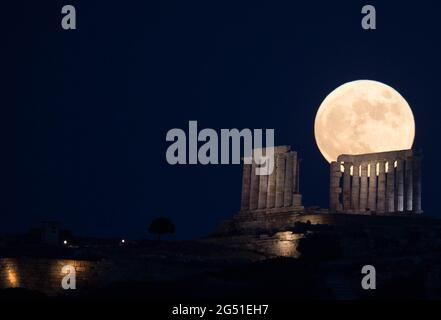 Cap Sounion, Grèce. 24 juin 2021. La pleine lune s'élève au-dessus du Temple de Poséidon au cap Sounion, à environ 70 km au sud-est d'Athènes, Grèce, le 24 juin 2021. Crédit: Marios Lolos/Xinhua/Alamy Live News Banque D'Images